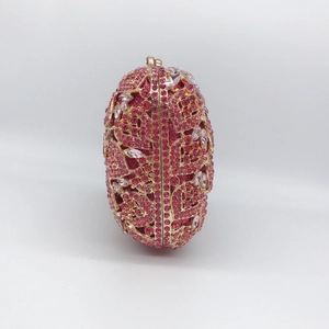 Detailed side view of pink rhinestone evening clutch with gold metal hollow floral design