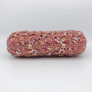 Detailed macro view of sparkling pink crystals and gold metal frame on luxury clutch