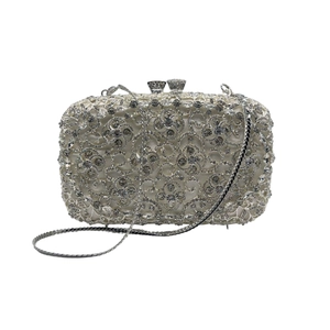 Detailed macro view of hollowed vine pattern and sparkling crystals on silver clutch