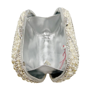 Top view of open silver evening clutch with pearl and rhinestone leaf patterns