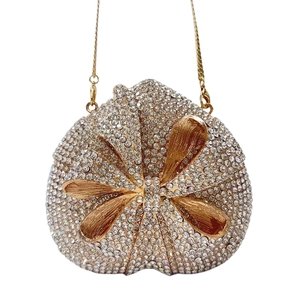 Detailed view of luxury heart clutch with full white rhinestones and golden bow accent