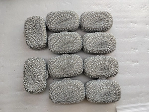 Flat lay view of multiple white pearl evening clutches with intricate leaf-shaped beadwork