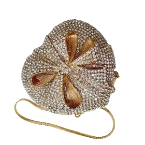 Macro detail of star-shaped evening clutch with sparkling rhinestones and gold flower petals
