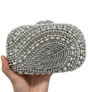 Detail of evening clutch featuring intricate pearl leaf patterns and crystal embellishments