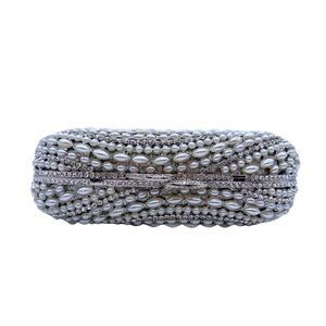 Detailed view of silver evening clutch with hand-set pearls and shimmering rhinestones