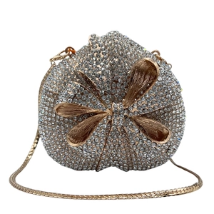 Macro detail of luxury heart-shaped evening clutch bag with rhinestones and golden bow