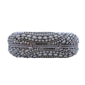 Close-up of elaborate pearl and crystal inlay detail on the silver evening clutch bag