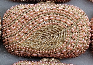 Close-up of pink marquise pearls and sparkling crystals on a luxury evening clutch bag
