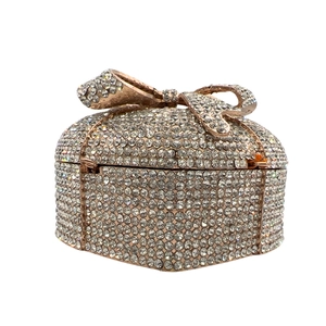 Macro shot of heart-shaped evening clutch with sparkling crystals and a rose gold bow detail