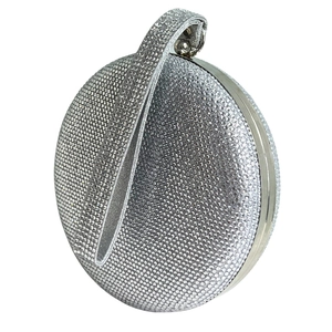Close-up of silver round evening clutch bag with sparkling rhinestones and metal handle