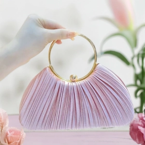 Dettaglio della borsa da sera in raso plissettato rosa chiaro con manico tondo dorato