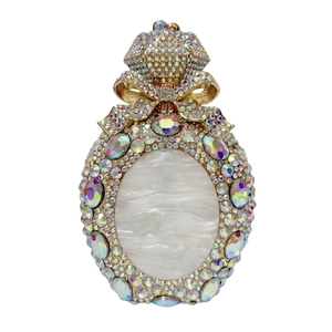 Macro detail of perfume bottle clutch bag featuring sparkling rhinestones and golden bow