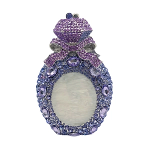 Macro shot of purple crystal perfume bottle clutch bag with diamond bow and shell finish