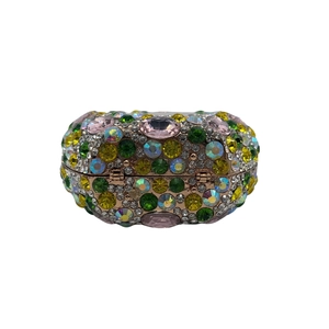 Close-up of colorful rhinestones and gold metal hinge on the oval shell evening clutch