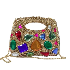 Detail of luxury gold dinner bag featuring multicolored rhinestones and chain strap