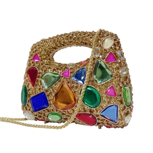 Detail of colorful waterdrop gemstones and rhinestones on the gold evening clutch bag
