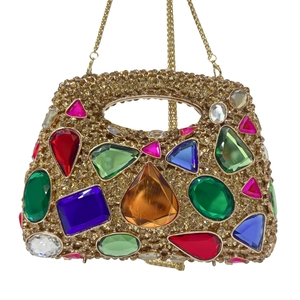 Macro detail of luxury evening bag with multi-colored gemstones and gold crystals