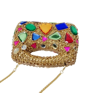Detailed macro view of luxury stone handbag with colorful rhinestones and gold chain
