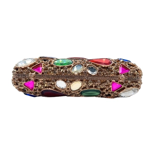 Macro view of champagne rhinestone oval evening clutch with colorful gemstone accents