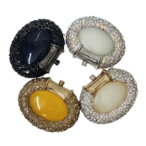 Set of four oval rhinestone clutch bags in black, opal, white and gold with gemstone