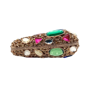 Detail of evening clutch featuring luxury crystals and colorful gemstones on gold frame