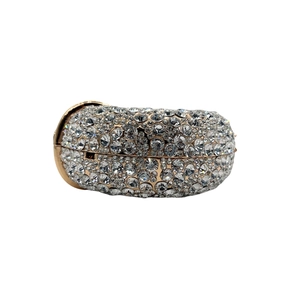 Detail of luxurious capsule evening clutch with gold metal frame and handset rhinestones