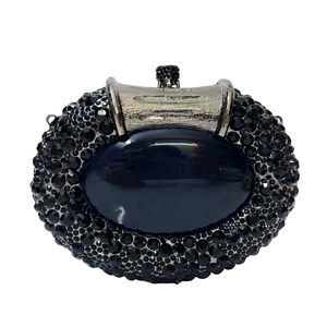 Macro detail of black rhinestone clutch with oval gemstone and silver metal clasp