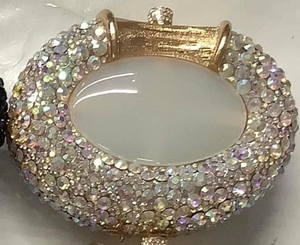 Close-up of luxury oval rhinestone clutch bag with iridescent crystals and golden lock