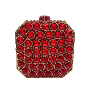 Macro detail of red rhinestone evening clutch with gold metal frame and crystals
