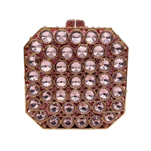 Macro shot of pink rhinestones and gold metal edge on the octagonal evening clutch bag