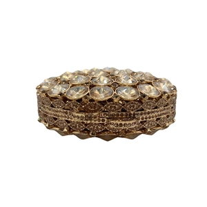 Macro detail of luxury evening clutch featuring large faceted crystals and golden metal frame