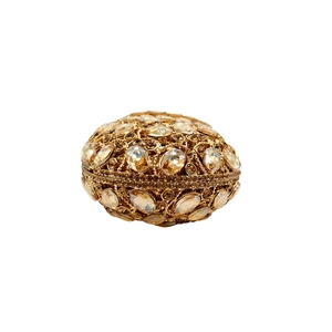 Detailed close-up of golden hollow metal egg structure with luxury inlaid crystals