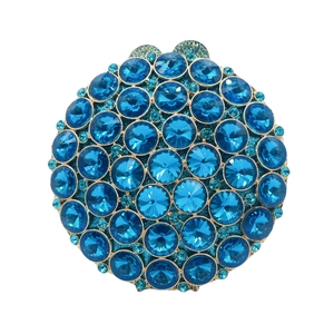 Detailed close-up of dark blue crystal rhinestones on a circular gold metal evening clutch