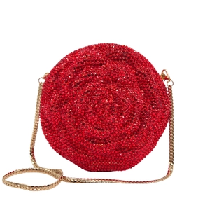 Detailed view of round red rhinestone evening clutch with fine gold chain strap