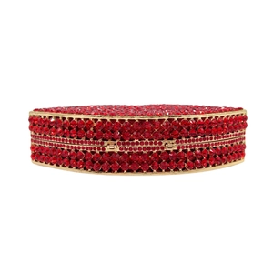 Macro detail of hand-set red rhinestones on a gold-plated evening clutch bag