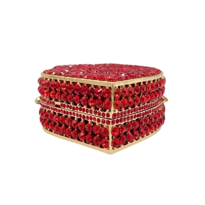 Elegant red rhinestone encrusted evening clutch bag with gold metal frame on white background