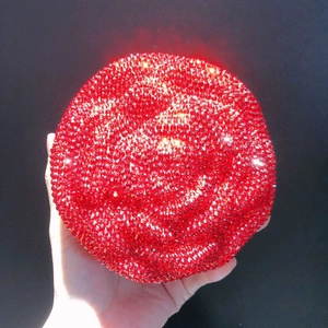 Detail of red floral clutch bag featuring densely set sparkling rhinestones
