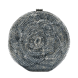 Macro detail of silver rhinestones forming a 3D rose pattern on a round clutch