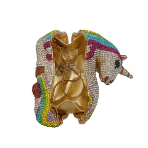 Detail of unicorn clutch interior featuring golden lining and metallic chain strap