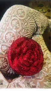 Detailed close-up of a red rose-shaped evening clutch bag encrusted with sparkling crystals