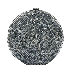 Macro view of crystal rhinestones forming a rose pattern on a silver evening clutch bag