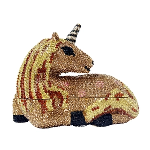 Macro detail of high-quality golden and brown rhinestones on a unicorn evening clutch bag