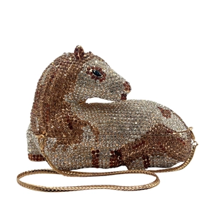 Macro detail of horse-shaped clutch bag with sparkling rhinestones and gold chain strap
