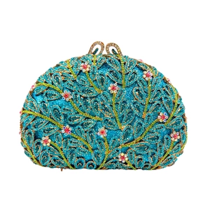 Detail of teal evening clutch with crystal leaf frame and handmade floral buckle
