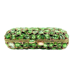 Close-up of emerald green rhinestones and crystals on a luxury rose gold evening clutch