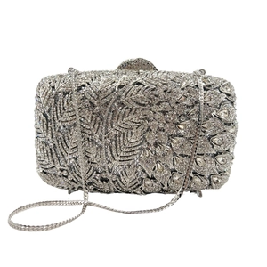Detailed macro of crystal-encrusted leaf and floral patterns on a silver evening clutch