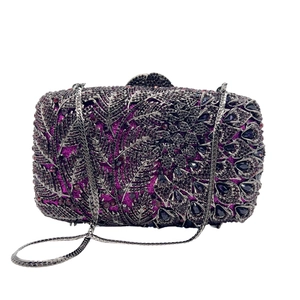 Detail view of purple crystal clutch featuring intricate dark leaf and rhinestone patterns