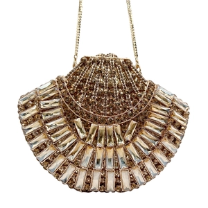Macro detail of champagne gold evening clutch featuring dense rhinestone crystals and chain