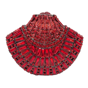 Detailed view of red shell-shaped evening clutch with pavé rhinestones and red emerald-cut gems