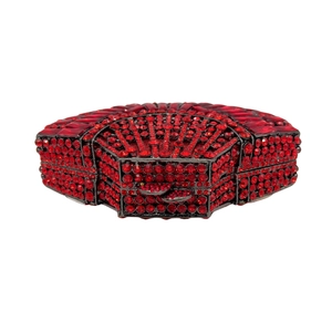 Detail view of red crystal evening clutch showing intricate hollow-out stone setting